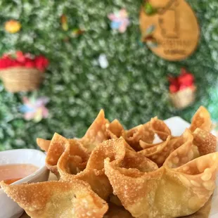 a plate of wontons with dipping sauce