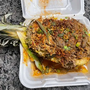 a pineapple in a styrofoam container