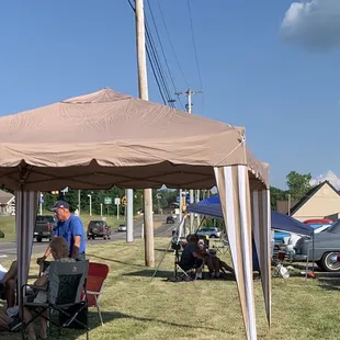 a group of people sitting under a tent