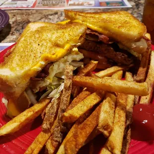 Cheezy burger (choice of cheese) w/ the usual fixing between 2 grilled cheese sandwiches. Added a fried egg &amp; bacon + home cut fries