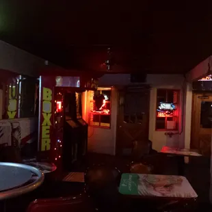 a dimly lit bar with neon signs