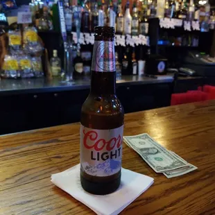 a beer bottle on a napkin on a bar