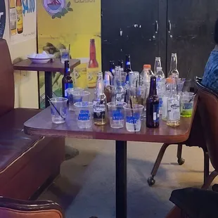 a woman sitting at a table with drinks