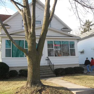 two people walking in front of the house