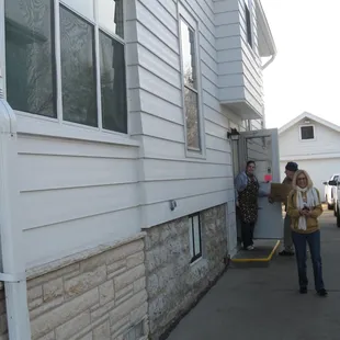 two men standing outside of a house