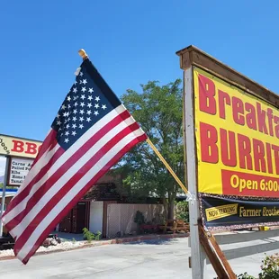 a large american flag in front of a restaurant
