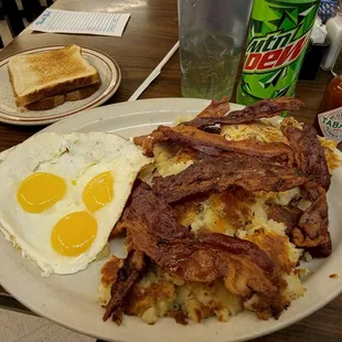a breakfast of eggs, hash browns, bacon and toast