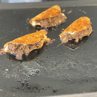 three pieces of meat on a grill