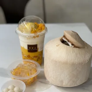 a coconut drink and a bowl of fruit