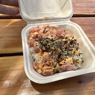 a hand holding a container of food