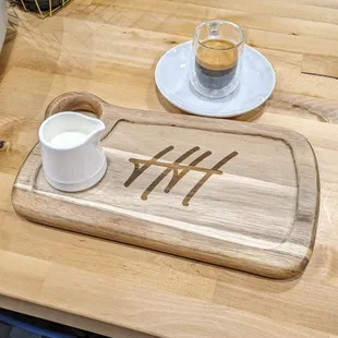 a cup of coffee and a wooden cutting board