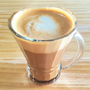 a cup of coffee on a wooden table