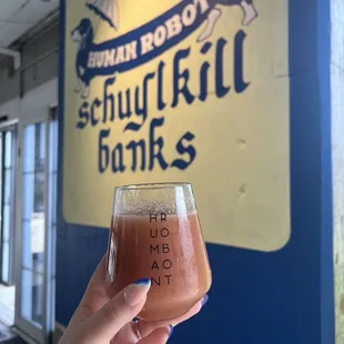 a hand holding a glass of beer