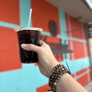a hand holding a cup of coffee