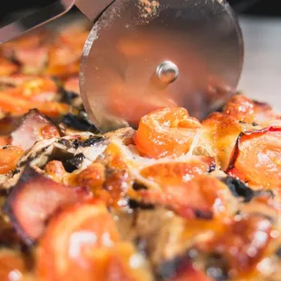 a person cutting a slice of pizza