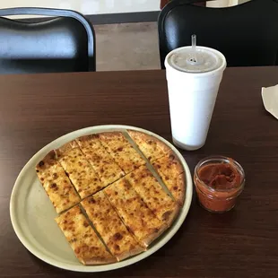 a plate of pizza and a drink on a table