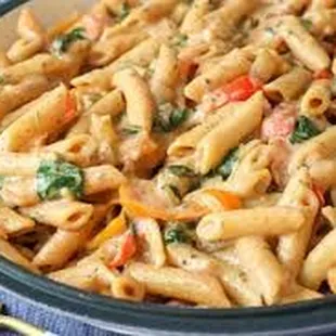 a bowl of pasta with chicken and spinach