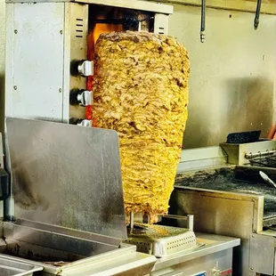 a large kebab being cooked in a commercial kitchen