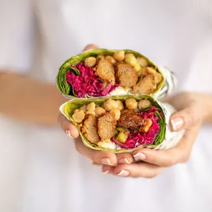 a woman holding a wrap of food