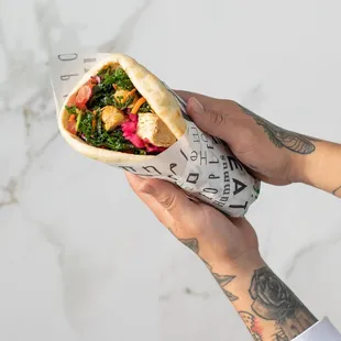 a hand holding a burrito