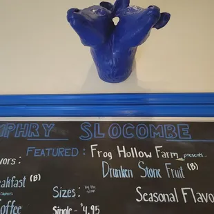 2 headed blue cow above a board describing flavors