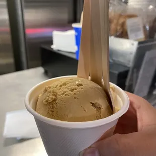 a hand holding a cup of ice cream