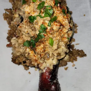 a piece of meat covered in sauce and garnished with parsley