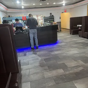 a man standing at a counter in a restaurant