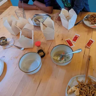 a group of people sitting at a table with plates of food
