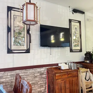 a dining room with a television and a brick wall