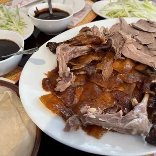 a plate of food with meat and sauces