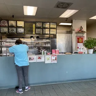 a woman standing at a counter in a restaurant