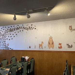 a dining room with a mural of animals on the wall