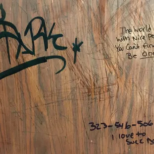 Laura graffiti on the men's bathroom wall