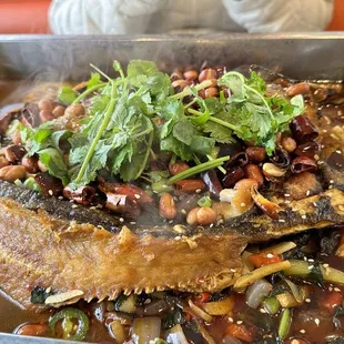 a dish of fish with beans and greens