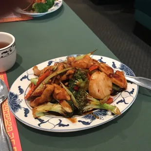 a plate of chinese food and a cup of tea