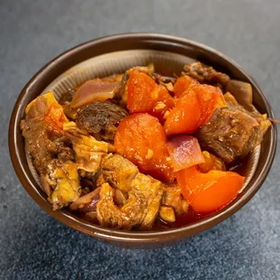 a bowl of stew with carrots and onions