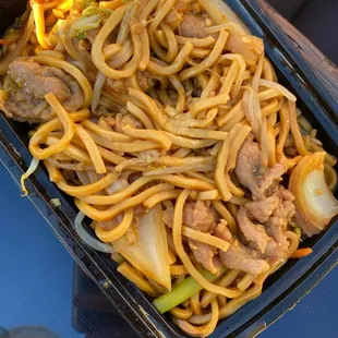a tray of noodles and meat
