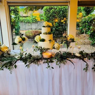 a table with a cake and flowers