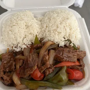 a takeout container with rice and beef