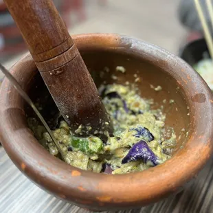 a wooden mortar with chopsticks in it