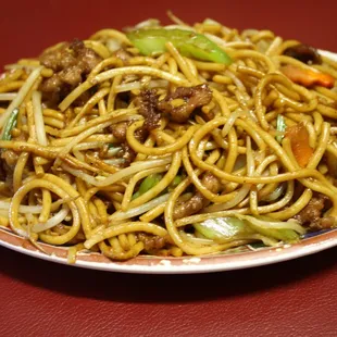 a plate of noodles with meat and vegetables
