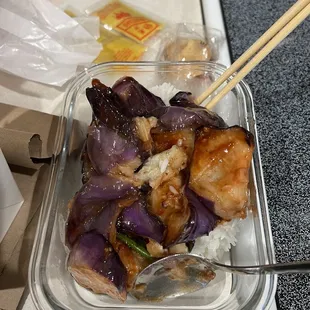 a meal in a plastic container with chopsticks