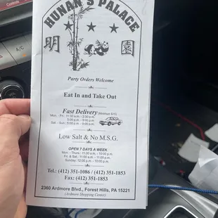 a person holding up a menu
