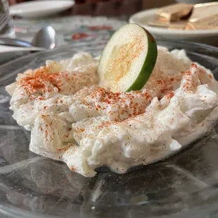 a plate of whipped cream with a lime slice on top