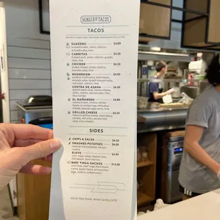 a hand holding a menu