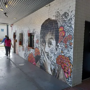 a woman walking past a mural