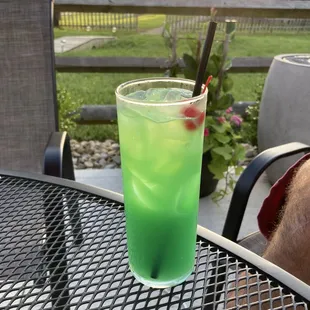 a glass of green drink on a table