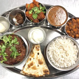 Mutton or Chicken or vegetarian thaali! A platter full of delicacies like, rice, naan, curries, yogurt and sweet dish!