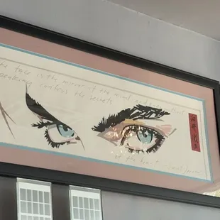 a framed drawing of a woman's eyes